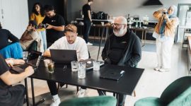 Ilustrasi anggota koperasi sedang berinteraksi dengan aplikasi digital di laptop dan ponsel mereka, menunjukkan kemudahan akses serta efisiensi dalam pengelolaan koperasi modern. Gambar ini menggambarkan bagaimana teknologi dapat memfasilitasi komunikasi dan transaksi antar anggota serta pengurus koperasi.