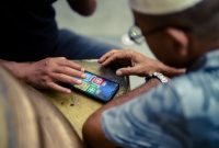 Seorang anggota koperasi dari daerah pedesaan tengah mengakses aplikasi koperasi digital melalui ponsel pintarnya, menunjukkan kemudahan akses layanan keuangan dan pasar bagi masyarakat di pelosok. Gambar ini merepresentasikan bagaimana digitalisasi koperasi menjembatani kesenjangan geografis, memberdayakan ekonomi lokal, dan meningkatkan partisipasi anggota dalam ekosistem digital.
