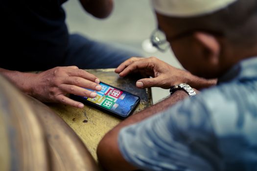 Seorang anggota koperasi dari daerah pedesaan tengah mengakses aplikasi koperasi digital melalui ponsel pintarnya, menunjukkan kemudahan akses layanan keuangan dan pasar bagi masyarakat di pelosok. Gambar ini merepresentasikan bagaimana digitalisasi koperasi menjembatani kesenjangan geografis, memberdayakan ekonomi lokal, dan meningkatkan partisipasi anggota dalam ekosistem digital.