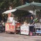 Seorang ibu rumah tangga sedang memilih sayuran di pasar tradisional Indonesia, mencerminkan aktivitas ekonomi sehari-hari serta tantangan dalam memenuhi kebutuhan pokok keluarga. Pasar seperti ini menjadi jantung perekonomian lokal, tempat transaksi dan interaksi sosial yang dinamis terjadi.