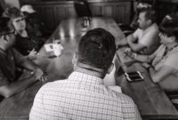 Suasana Rapat Anggota Tahunan (RAT) yang kondusif, menampilkan para anggota koperasi berdiskusi dan memberikan suara untuk memutuskan berbagai agenda penting. Pertemuan ini adalah cerminan nyata dari demokrasi internal dalam sebuah koperasi.